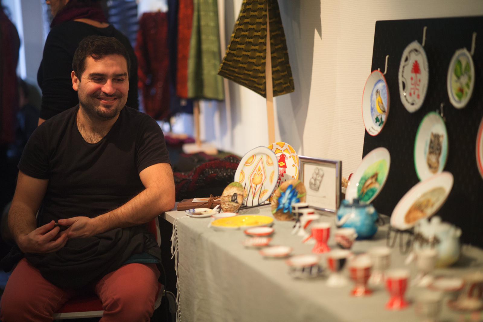 Un artista en su puesto con vajilla pintada a mano en el mercado